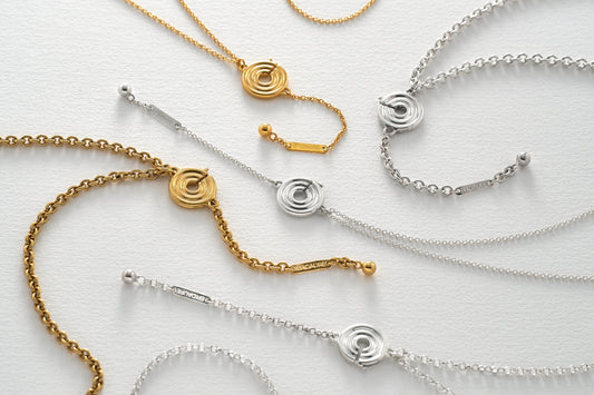 Colliers porte-bague Epidaure en argent massif et plaqué or posés à plat, avec leur pendentif rond